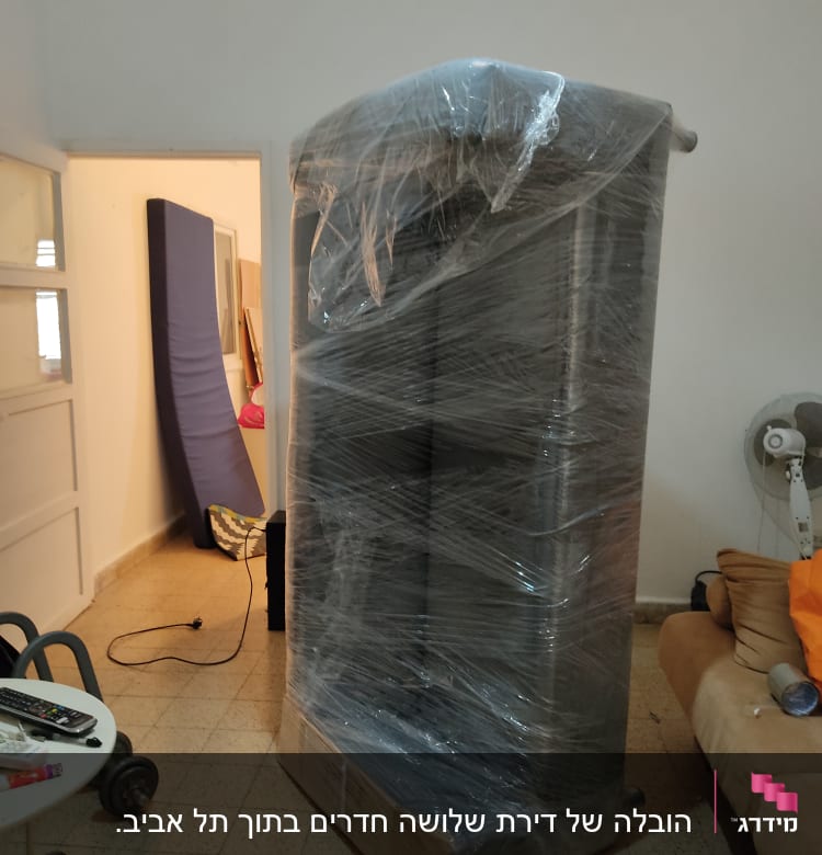 רהיט עטוף בניילון מוכן להובלה בחדר